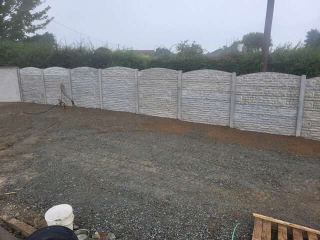 Old rotten timber fence in a hillside garden before replacement